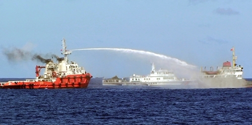 In this photo released by Vietnam Coast Guard, a Chinese ship, left, shoots water cannon at a Vietnamese vessel, right, while Chinese Coast Guard ship, centre, sails alongside in the South China Sea off Vietnam's coast, Wednesday, May 7, 2014. Photograph by: AP Photo/Vietnam Coast Guard , Postmedia News Read more: http://www.vancouversun.com/news/world/Vietnamese+vessels+collided+with+Chinese+ships+near+disputed/9814590/story.html#ixzz3126QQw7O