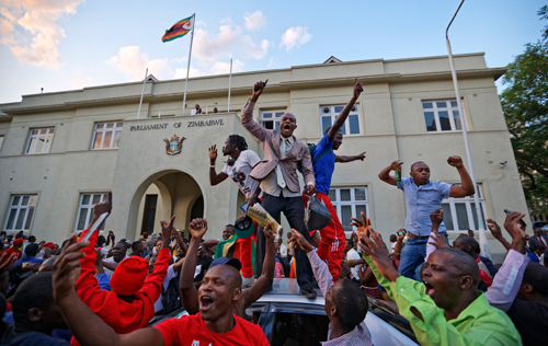 Người dân Zimbabweans ăn mừng ông Mugabe từ chức bên ngoài quốc hội ở thủ đô Harare. Ảnh: AP.