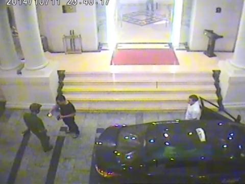 Hình ảnh camera của khách sạn ghi lại cảnh người đàn ông áo đen đưa một thứ cho người mặc sắc phục công an xem. Sau đó người mặc sắc phục bỏ đi.